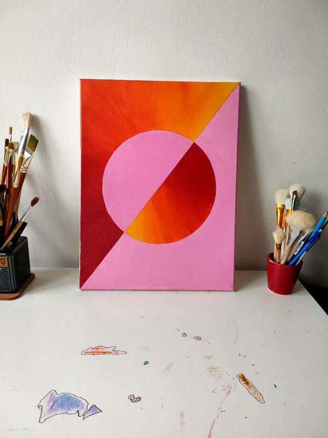 A large pink circle divided by a diagonal, on a pink ground with an orange and red corner.