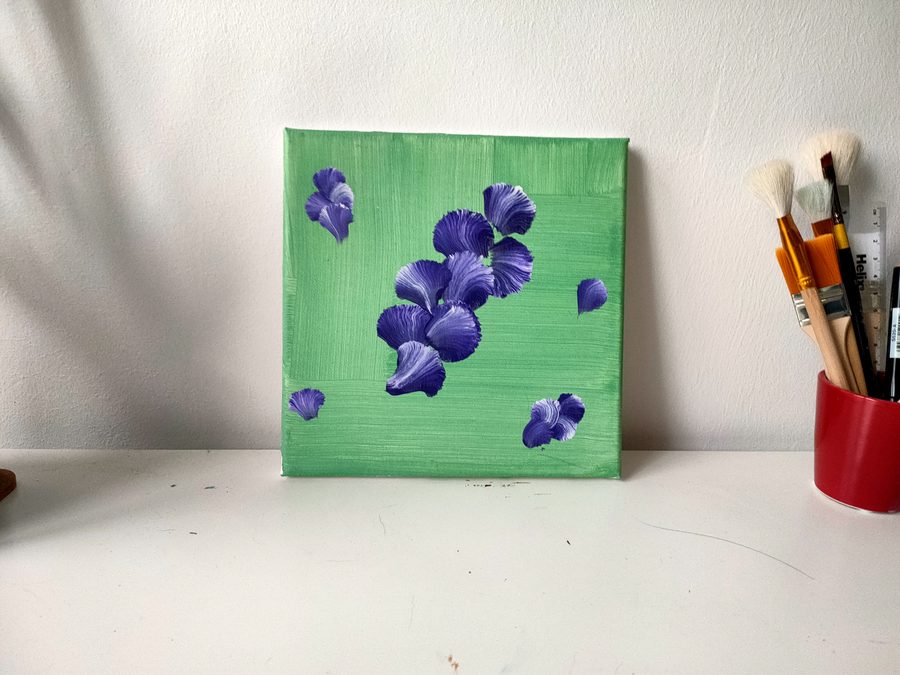 Purple iris petals falling across a bright green ground.