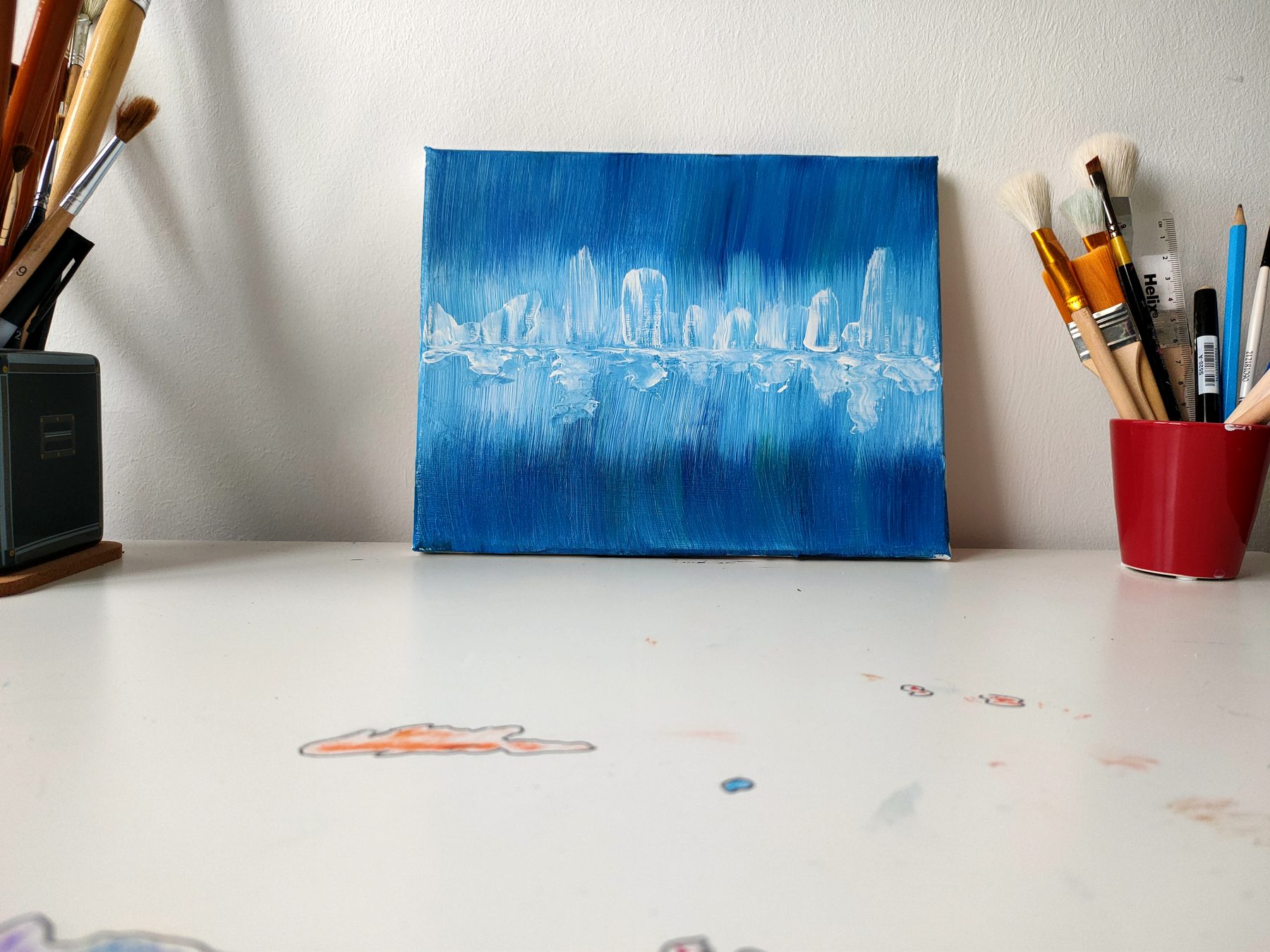 A white palette-knife skyline and its reflection across a blue field.