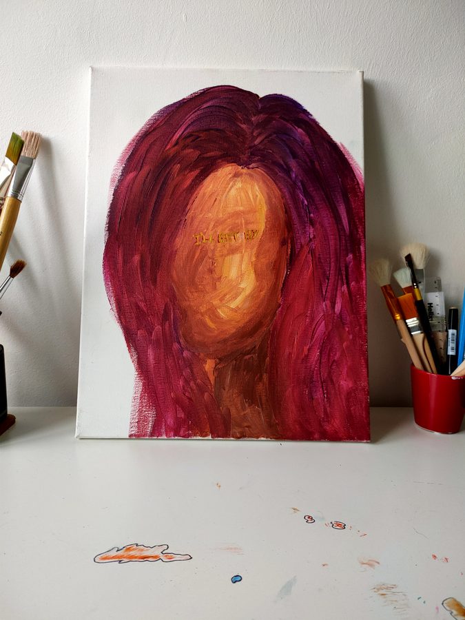 A face wrapped in flowing red and magenta hair.
